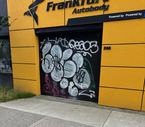 Graffiti on rolling shutter at Frank & Sons Autobody.