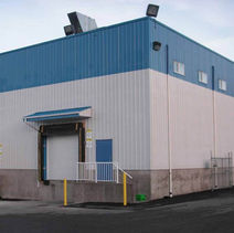 Exterior view of a building with a loading dock and blue roof