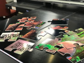 Custom puzzle pieces with text and images on a dark surface