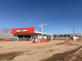 Gas station with an orange sign and several fuel pumps