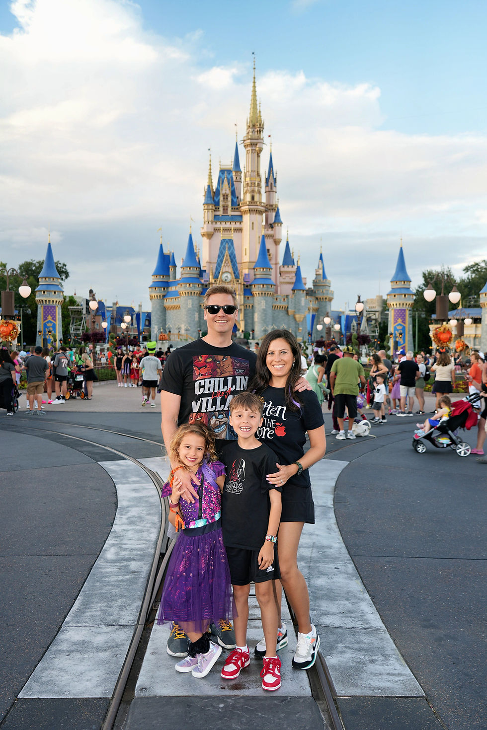 Family posing in front of Cinderella Castle at Magic Kingdom in Walt Disney World