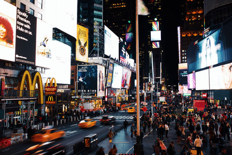 Times Square at night with cars blurred in motion
