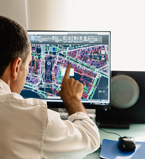 Architect drawing with cad software designing building. Rear view. He is pointing the scre