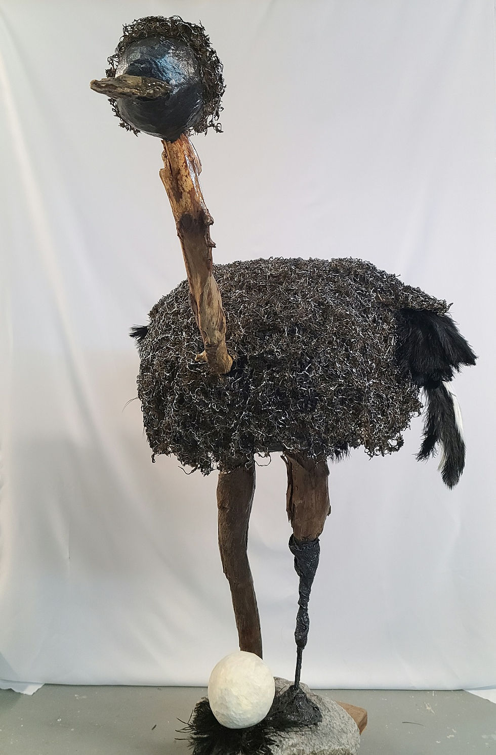 Sculpture de jardin ou de maison. Autruche de tissu durci, bois flotté verni, plumes sur socle en pierre.