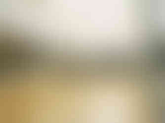 A large, brightly lit museum gallery with paintings covering the walls.