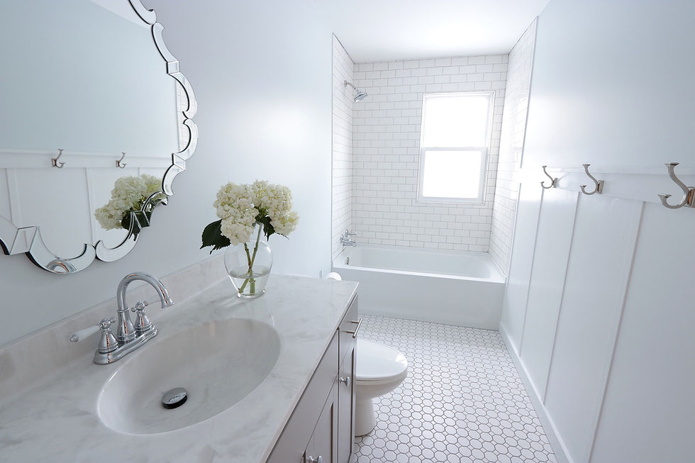 Light and bright bathroom designed by Souled Home Design of State College, PA. The uniquely shaped mirror adds the wow factor in this crisp white bathroom.