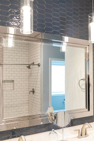 Blue tiled vanity wall with modern pendant lights.