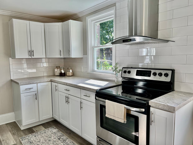 Port Matilda Home staged by Souled Home Design. Photo features the kitchen with white cabinets, stainless steel range and hood, decorative accents on the countertop