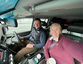 Woman and Espinar smiling in front of car