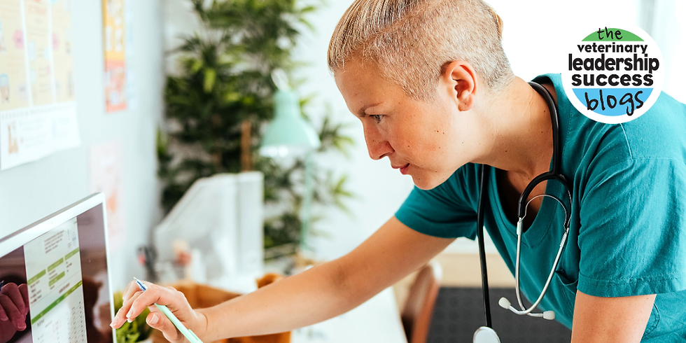 Woman in vet practice leans over computer, studying closely.