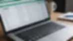 Close-up view of a laptop displaying coding in a spreadsheet application