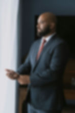 a man in a suit with bald and bearded look