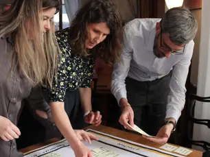 Trois personnes réfléchissent autour d'une table avec des post-it