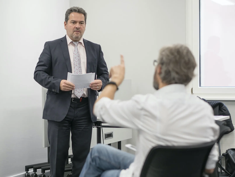 Un homme debout présente, un deuxième pose une question