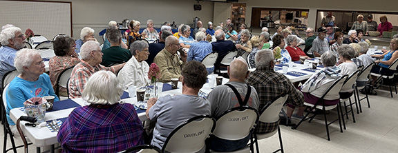Seventy-five seniors enjoying conversation prior to the luncheon