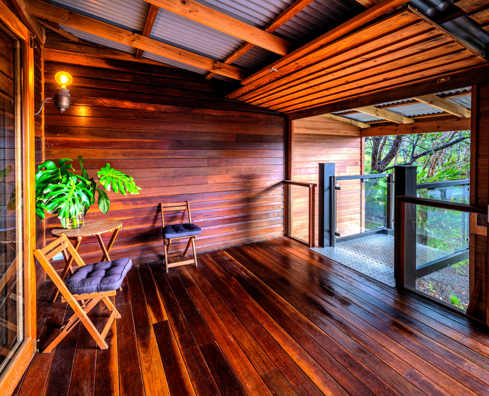 Tranquil beach house veranda with wooden floors and chairs
