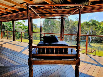 verandah sunrise, outdoor yoga, journaling spot, eco timber deck, bush retreat, Tranquilo Beach House, Woolgoolga, peaceful stay, coastal verandah, morning light, Airbnb escape, VRBO listing, timber tones, nature backdrop, boho vibes, open-air seating, relaxation retreat, wellness holiday, barefoot luxury, scenic verandah
