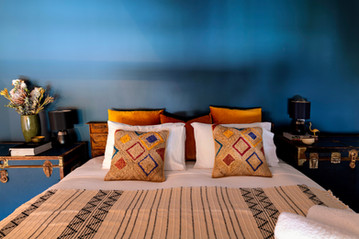Cozy bedroom with colorful pillows and blue walls