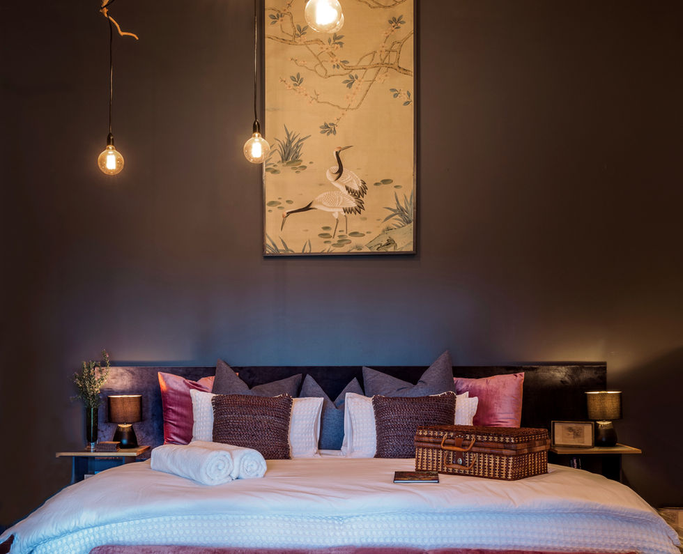 Tranquil bedroom with king-size bed, crane artwork, and unique lighting