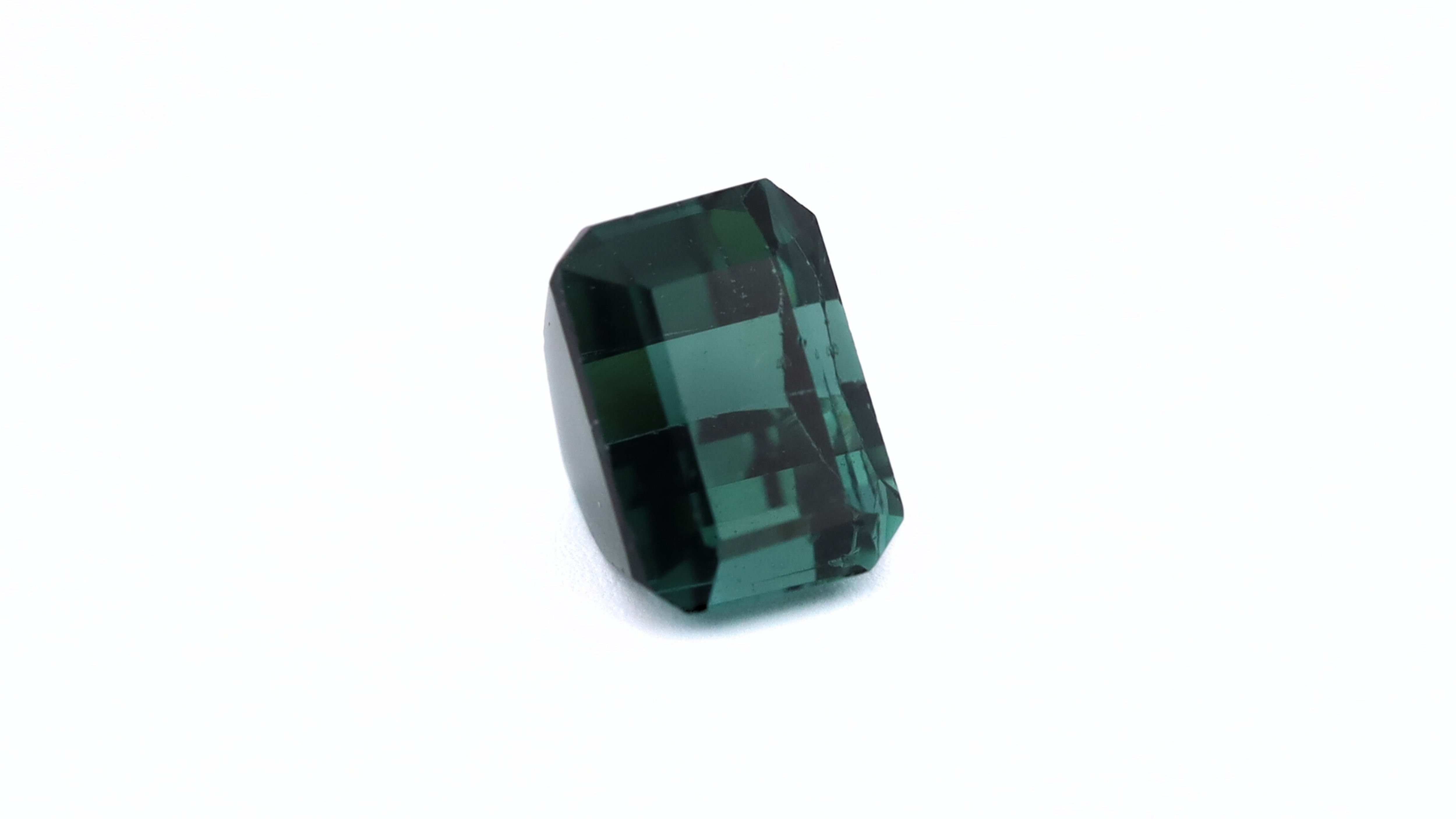 Side photo of a rectangular cut deep green (Bluish) Tourmaline, measuring 6.23x4.38x4.39mm and weighting 1.09ct.
