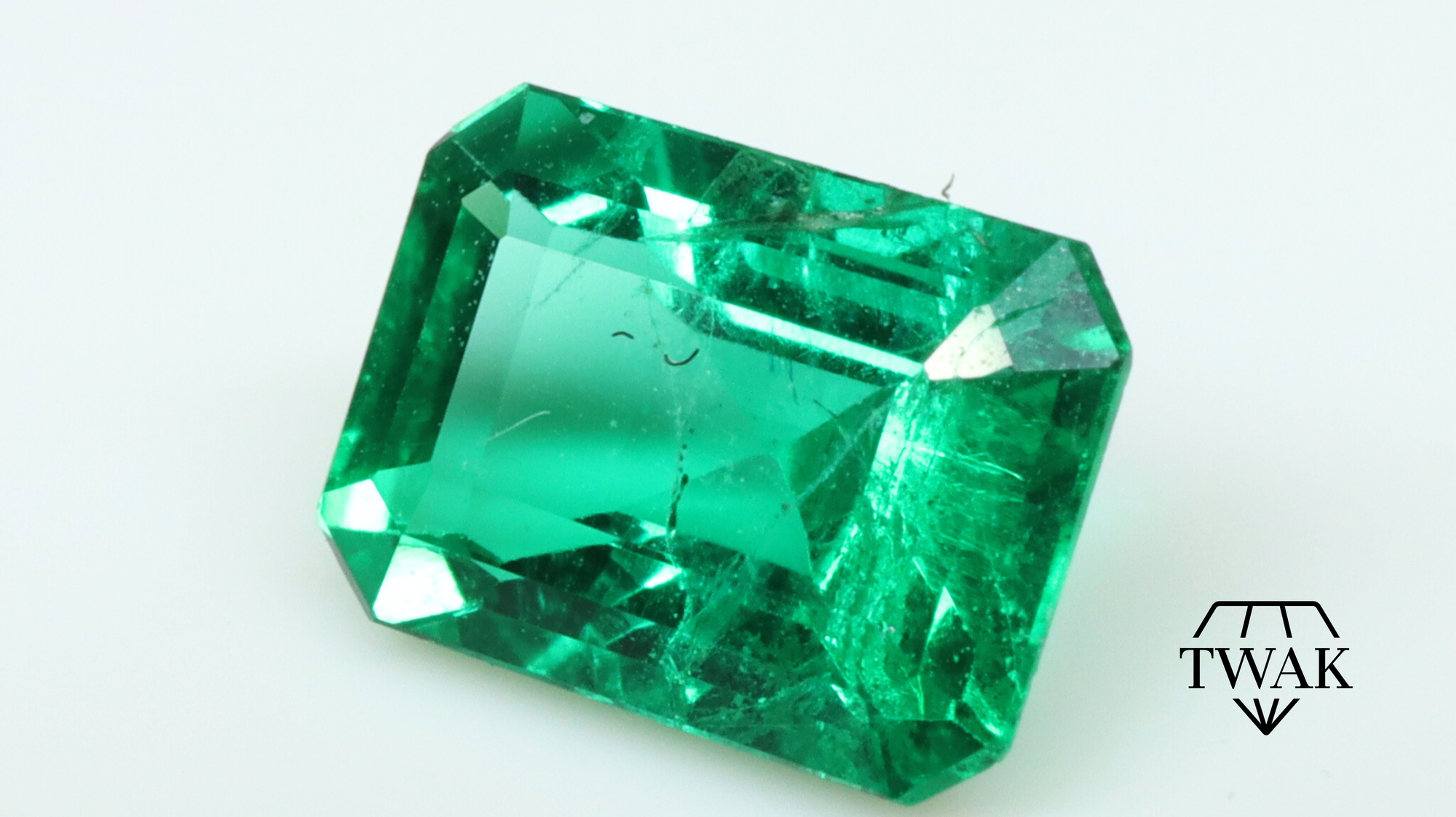 Side photo of a natural 6.5x4.5mm Emerald from Brazil with minor oil only.