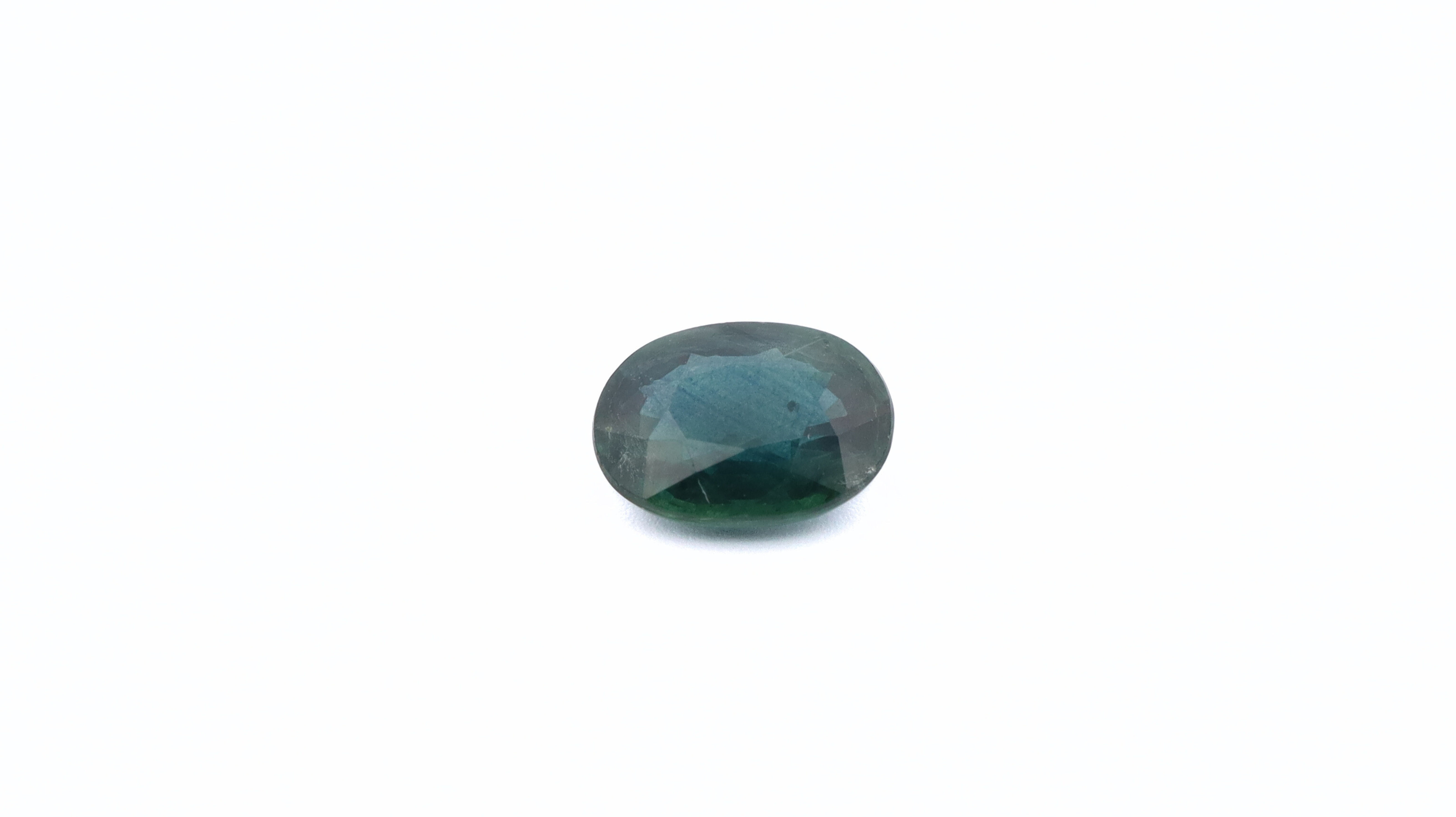 Front photo of a green Sapphire, oval cut, measuring 6.91x5.15x3.00mm and weighting 1.07ct. With a white background.