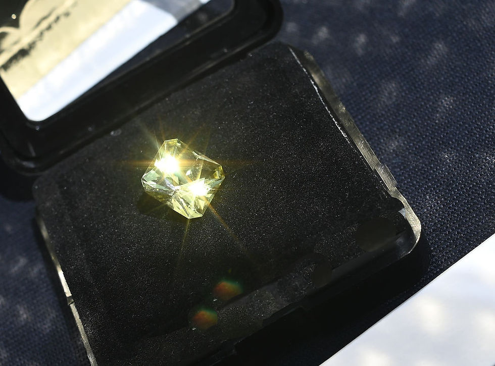 A precision cut Heliodor, under direct daylight. The stone is on a open box, with a black background, showing a strong color saturation and excellent light reflection.