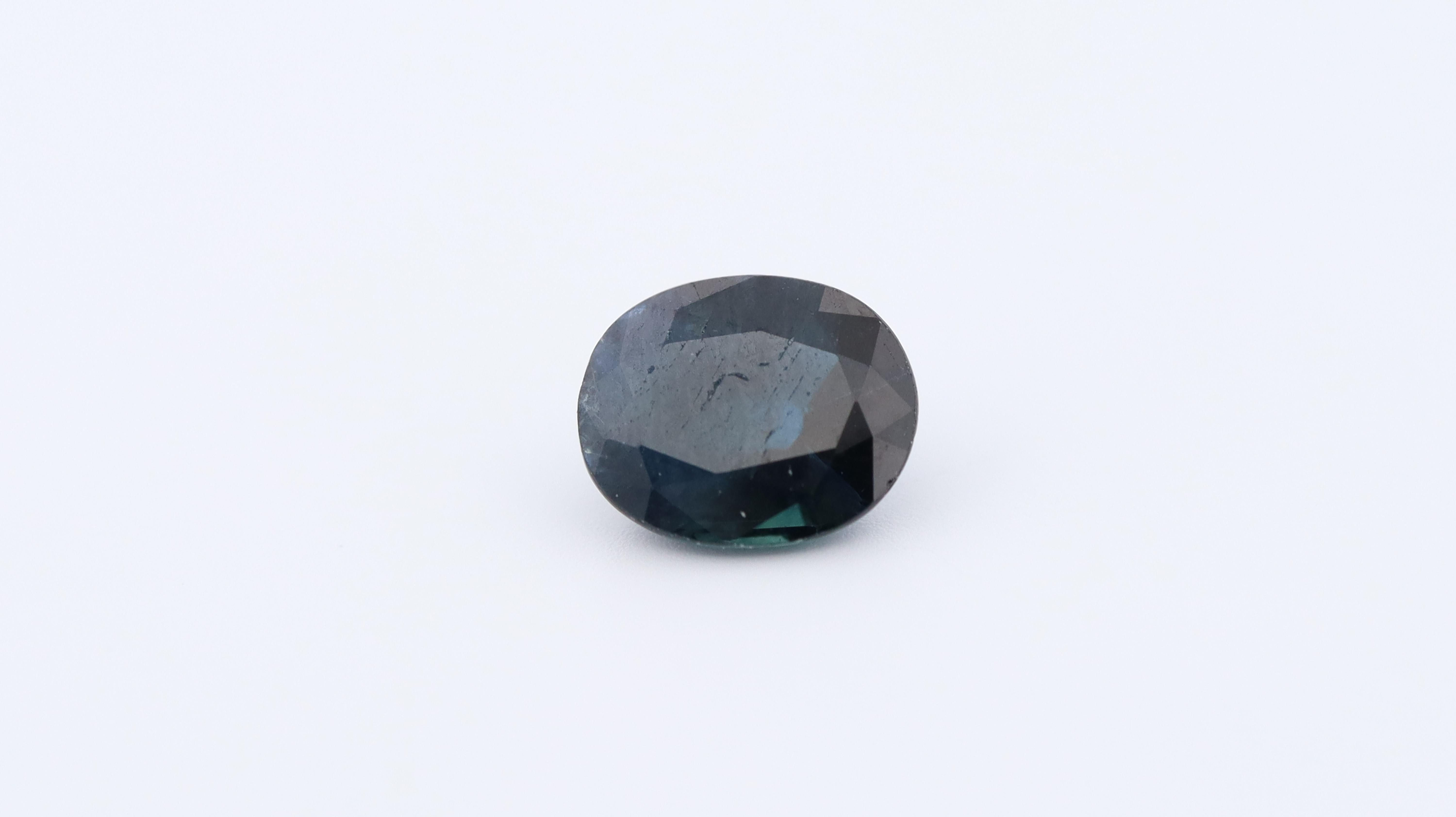 Photo of a natual oval sapphire, color diffused, with a neutral background.