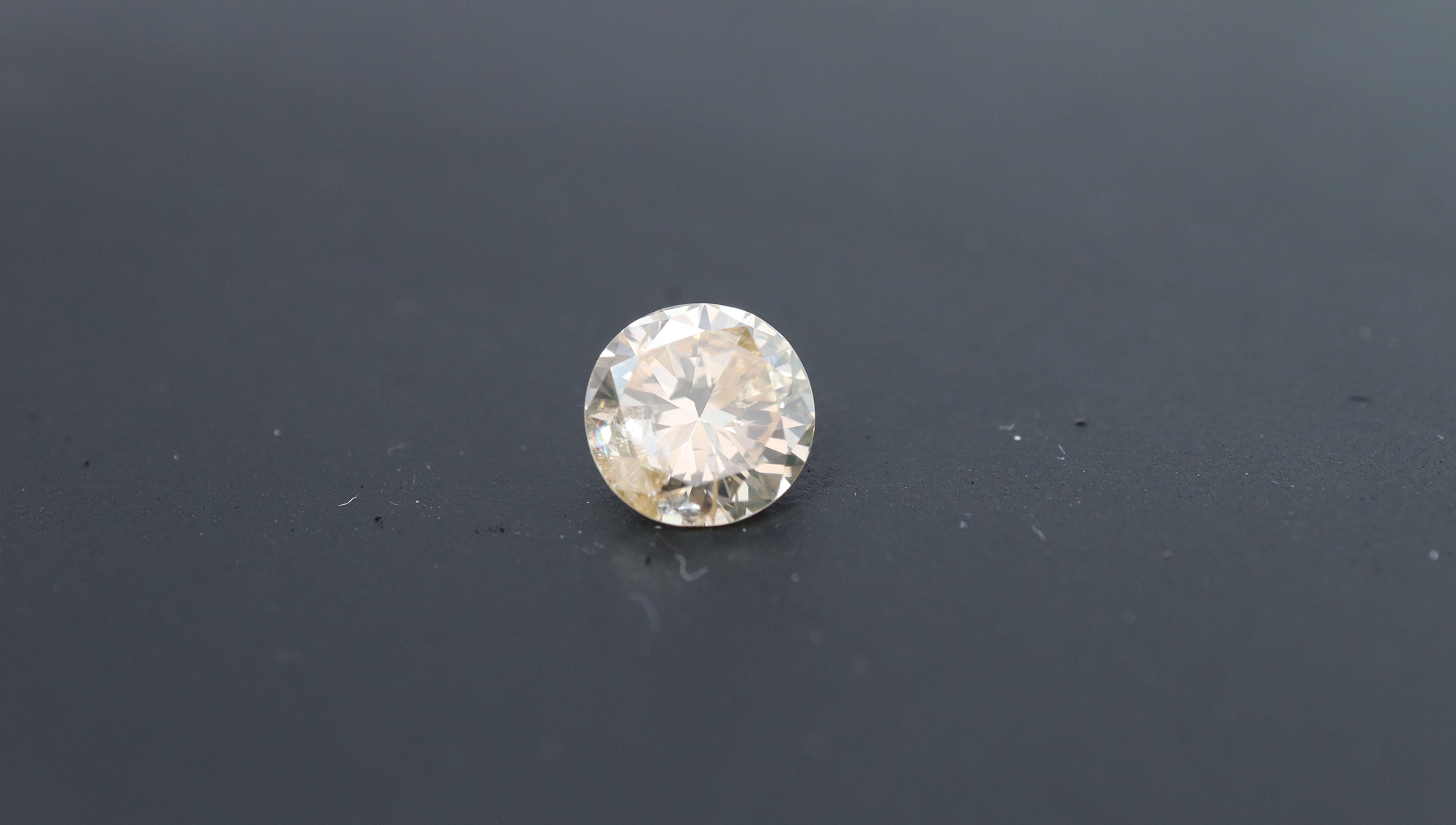 Photo of a natural round polished diamond with 1.03ct, with a light brown undertone, better know as a champagne diamond.
