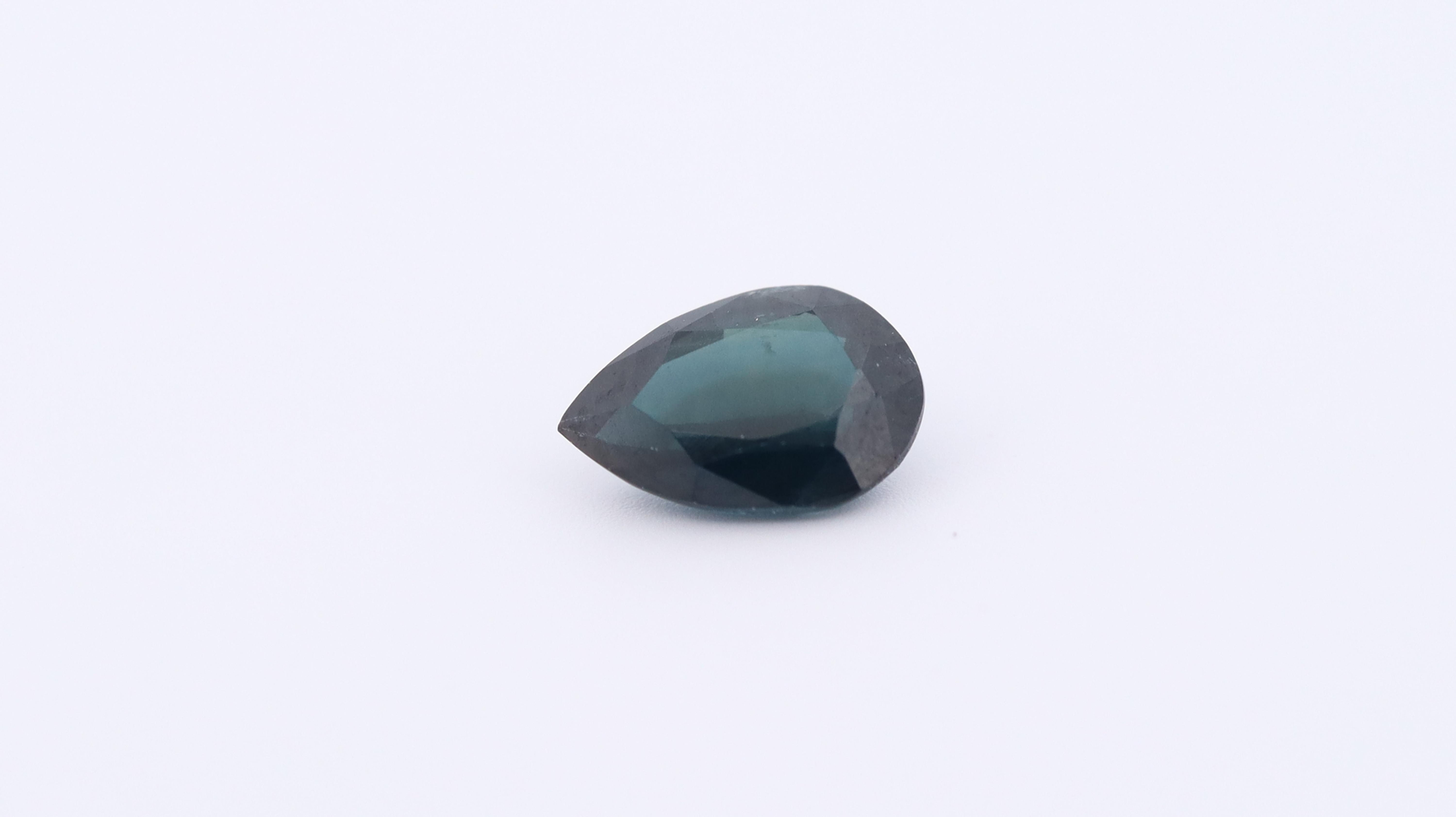 Photo of a natural Pear cut deep Green Sapphire, measuring 7x5x3mm and weighing 0.95ct.