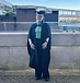 Me on graduation day, in my black graduation cap and gown. Wearing a green button-up shirt