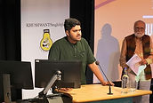 KSLF - Rishi Dastidar on stage behind podium giving a speech.
