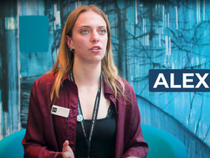 Macalester College student Alex Bordelon standing in front of artwork during her internship at the Minnesota Museum of American Art in St. Paul.