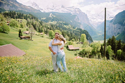 Couple hugging in a Wengen wildflower field with Lauterbrunnen Valley in the background