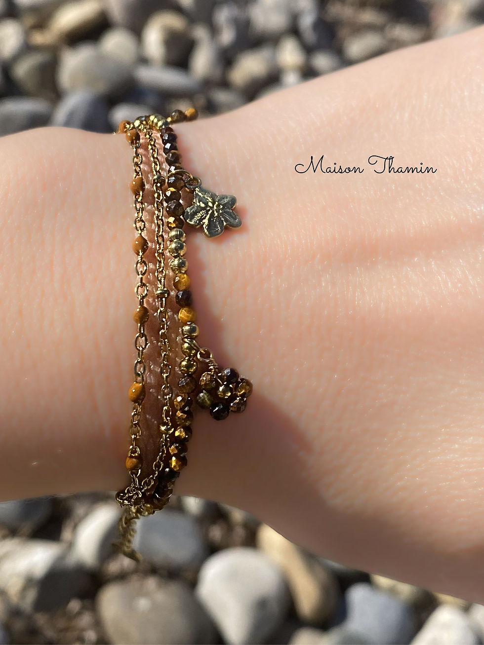 Miniature : Gros plan sur un bracelet en acier inoxydable doré avec breloques marron
