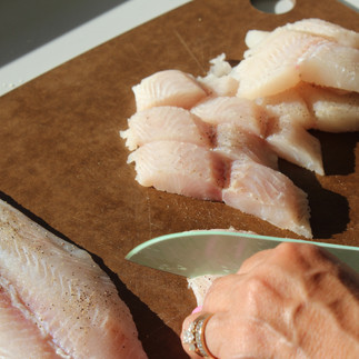 fish filets being cut into slices