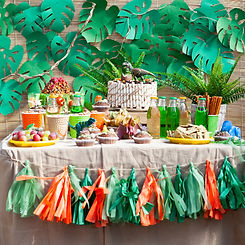 candy bar on children's birthday. cake with dinosaur and sweets, ornaments in green tones.