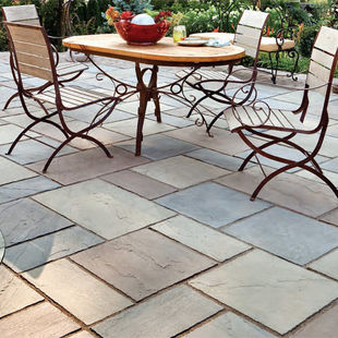 Patio with tumbled pavers and a set of chairs around a table