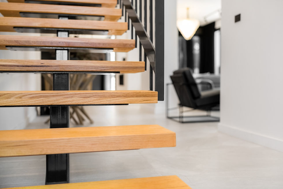 Close-up view of a floating timber staircase with black metal supports in a contemporary Sydney home, featuring a minimalist interior with high-end finishes.