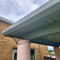 Professional bird control netting installed on a building canopy to prevent pigeons and seagulls from nesting and roosting.