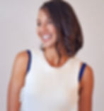 Woman wearing scalloped blue bra straps in white knit tank top.