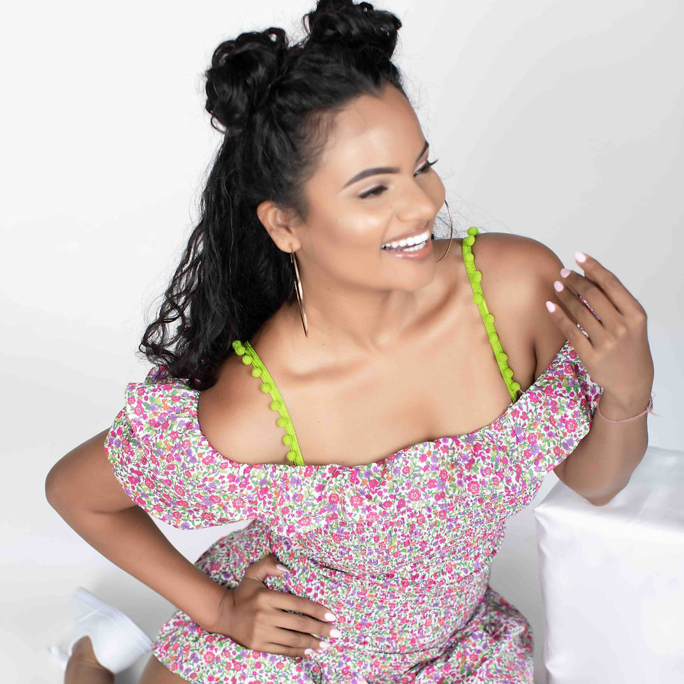 Thumbnail: Woman wearing green bra straps with pompoms in a floral off the shoulder top.