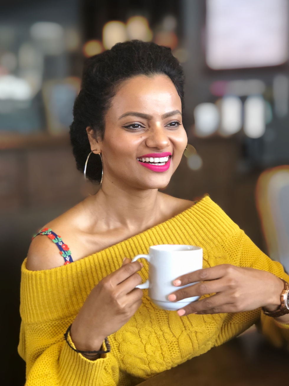Miniatura: Woman wearing bra with flower straps holding a mug. Blue floral bra straps with yellow off the shoulder sweater.