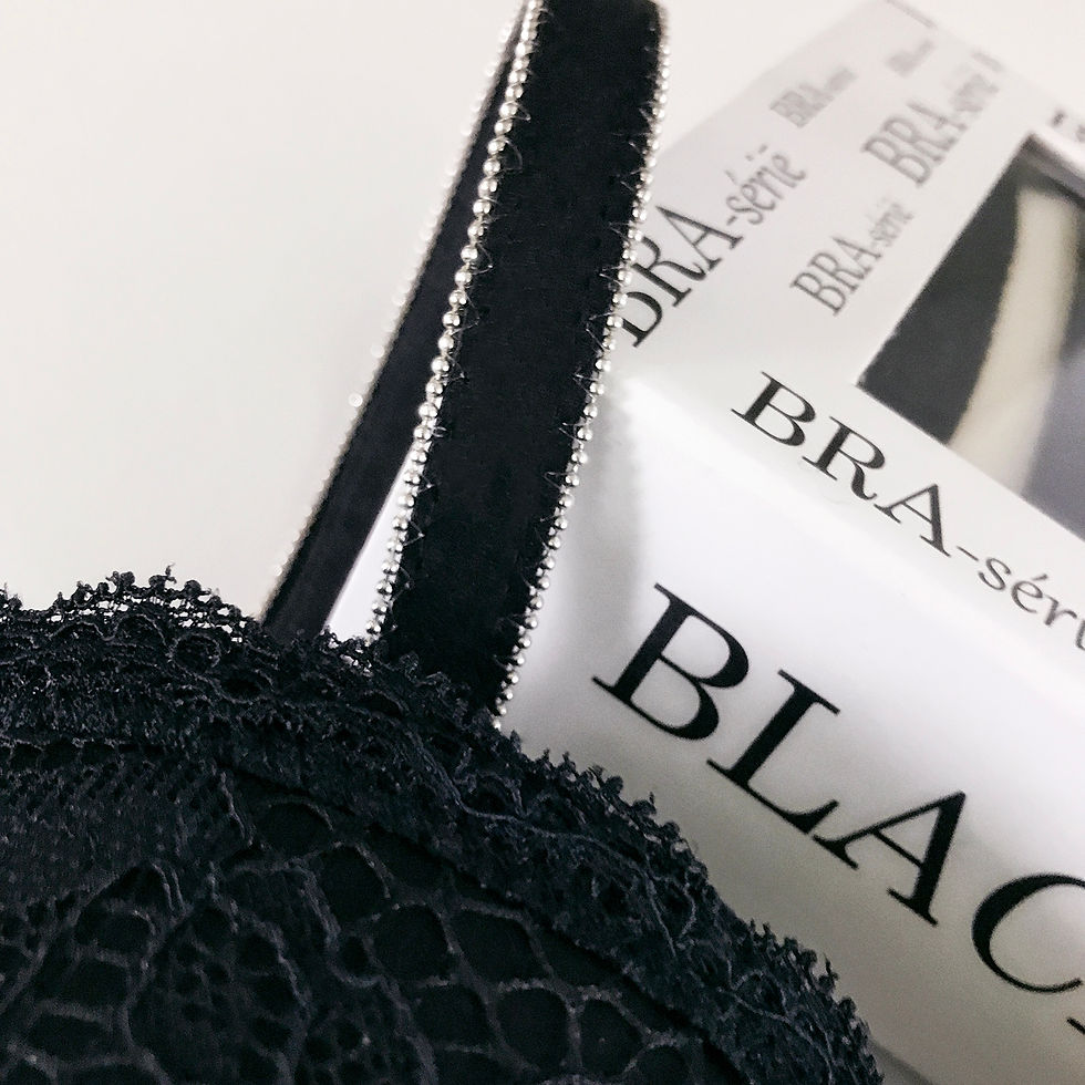 Miniatura: Black bra straps with silver beads on lace bra, close-up in front of box.