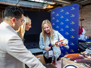 An exhibitor dispensing whiskey samples at The Summit