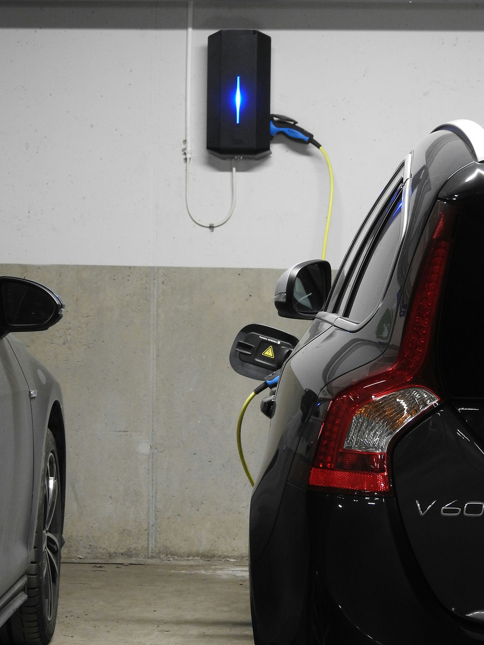 Un véhicule hybride rechargeable en train de charger à coté d'un véhicule hybride non rechargeable micro-hybride