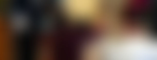 Madre y niños se arrodillan y tocan una cruz reliquiario sobre un altar mientras un hombre supervisa la veneración.