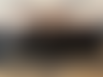 Grupo de hombres sonrientes, muchos con collares de cruces, posan en una sala. Fondo gris y suelo de alfombra. Ambiente formal.