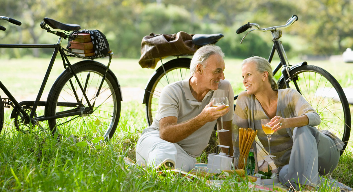Casal desfrutando de um momento ao ar livre, associado a um estilo de vida saudável com alimentação plant-based e à longevidade