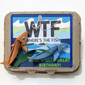 Fishing-themed egg gift carton with bold lettering and hand-folded origami salmon on an underwater background